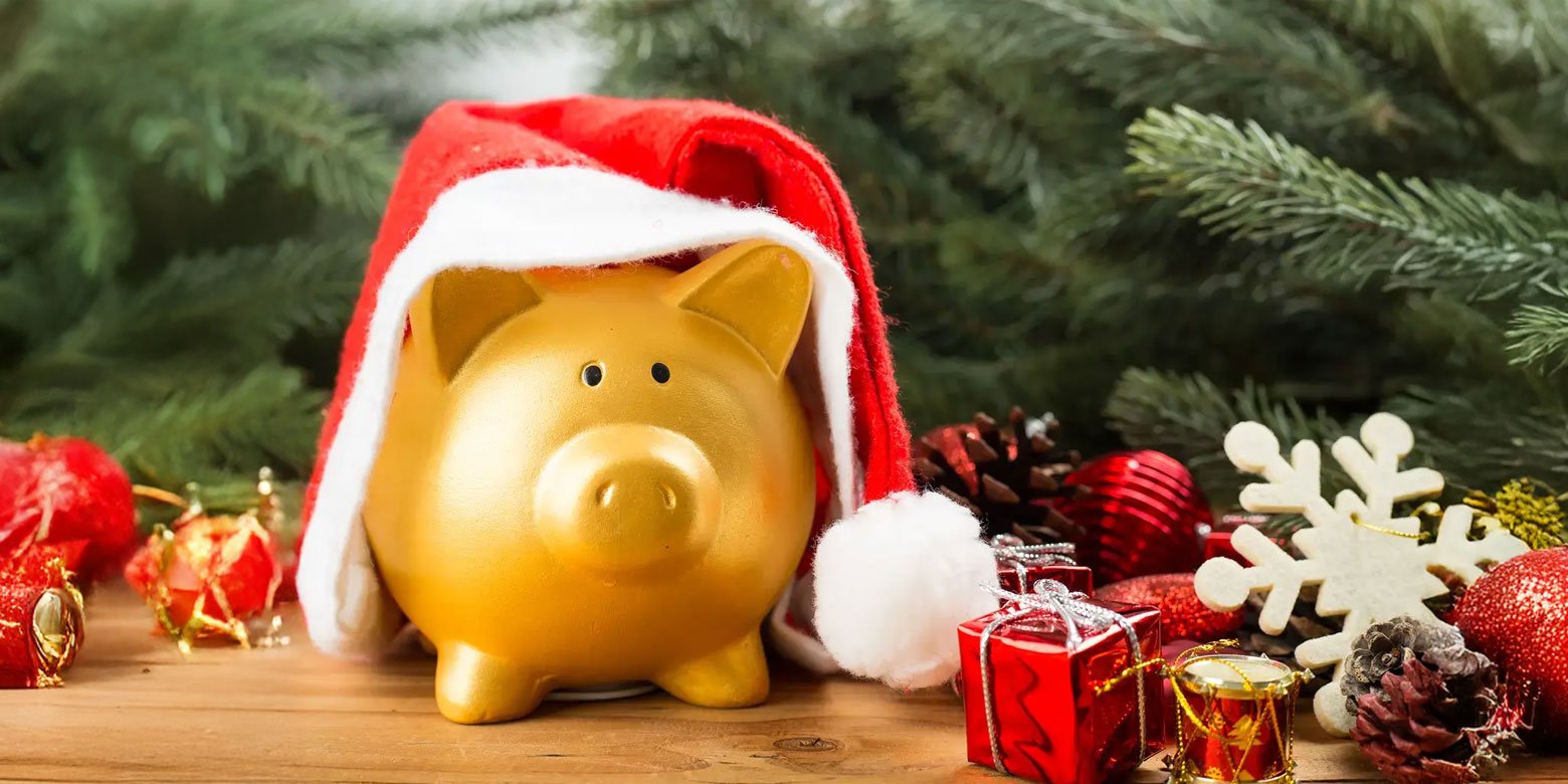 Golden piggy bank with a Santa hat and presents