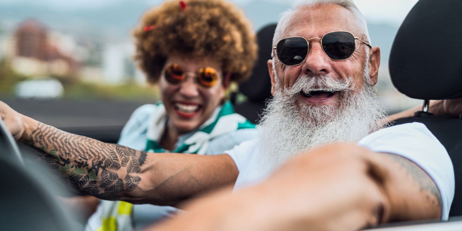 Retired couple driving in a convertible