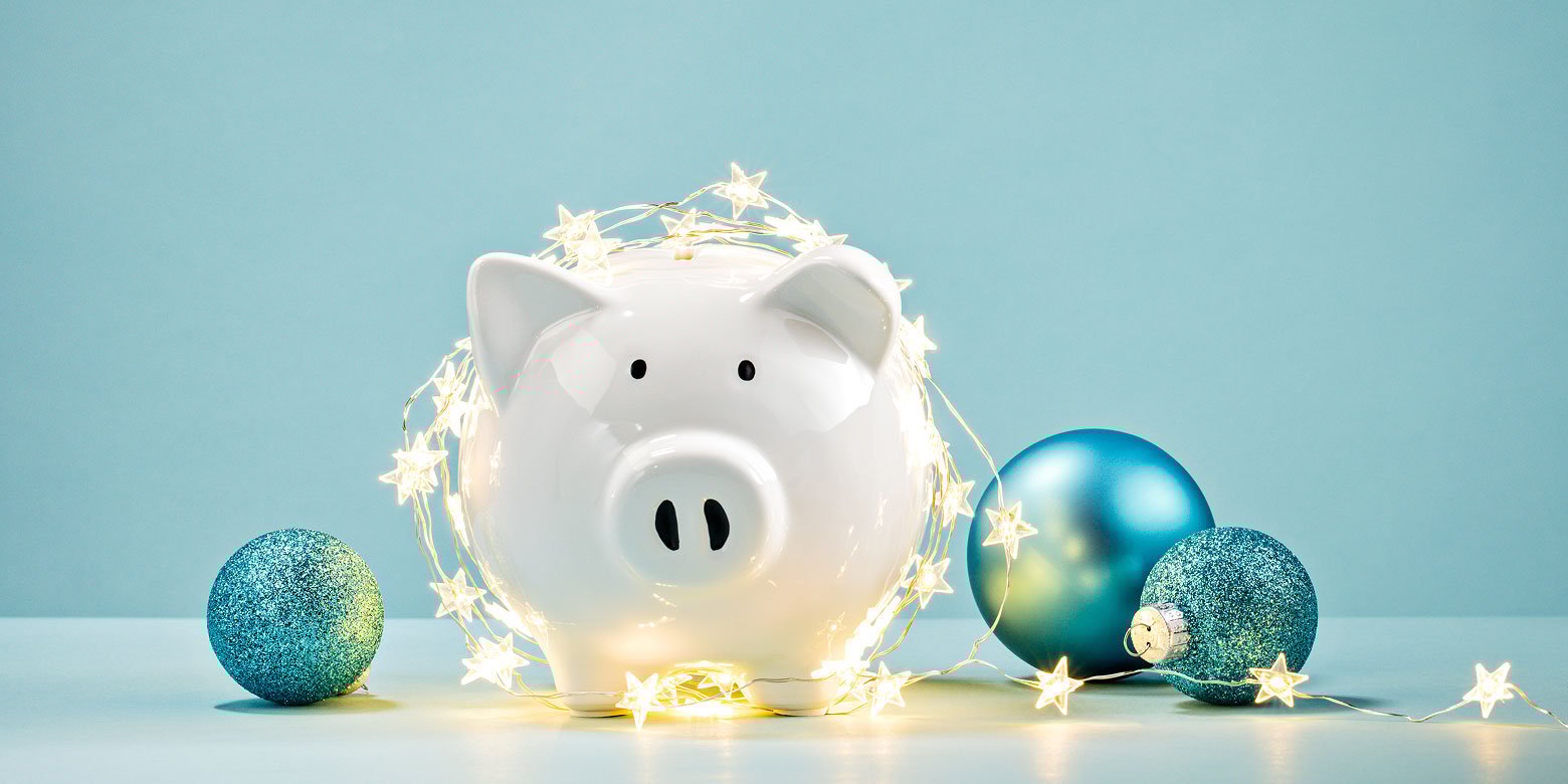 Piggy bank surrounded by Christmas lights and ornaments