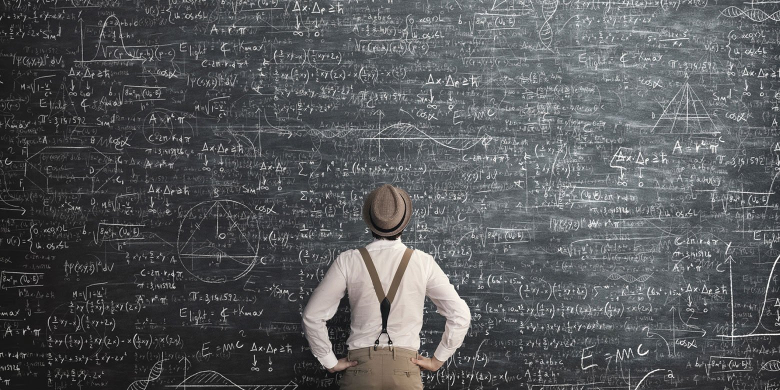 Man staring at blackboard with complex mathematical computations