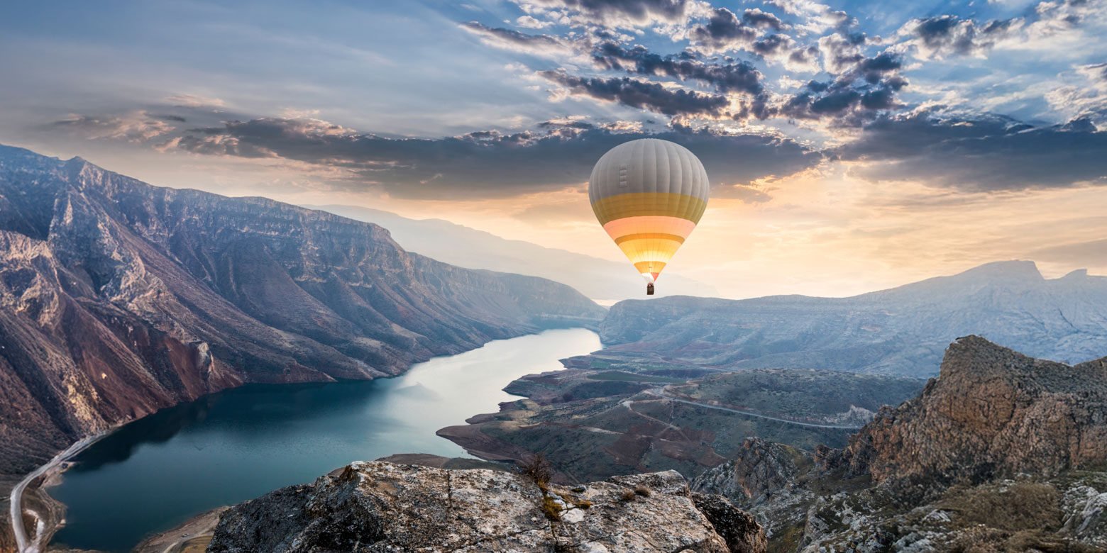 Hot air balloon over river and canyon