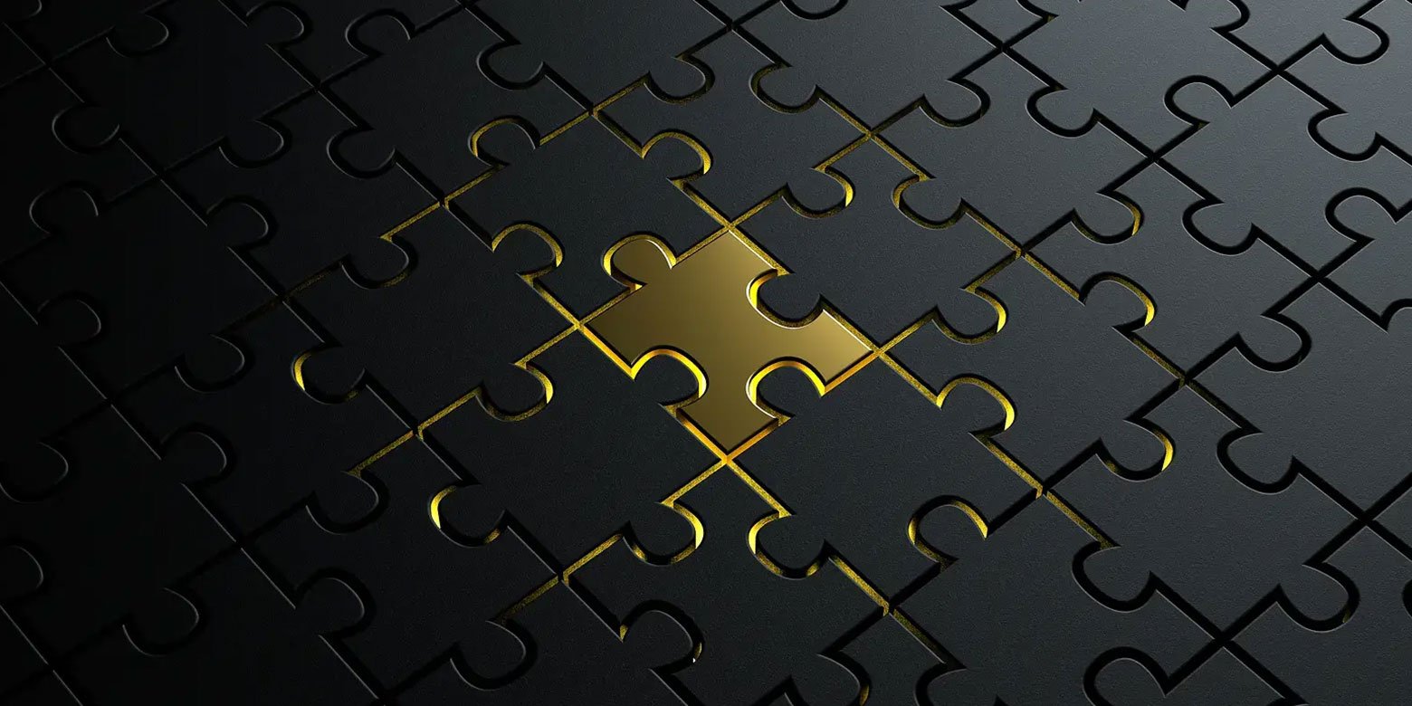 Black jigsaw puzzle with one gold piece in the middle
