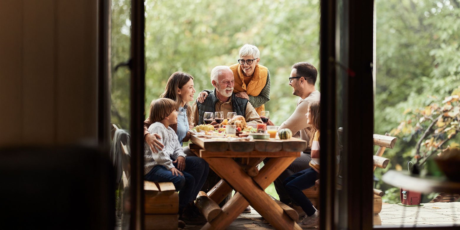 Grandparents, parents and children having an outdoor picnic on the deck