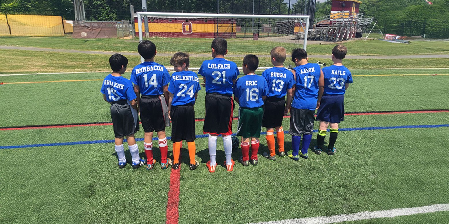 Youth soccer team standing together with unique names on their jerseys