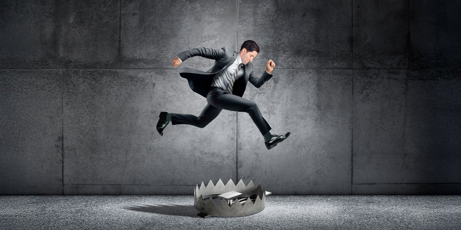 Man in a suit jumping over a trap