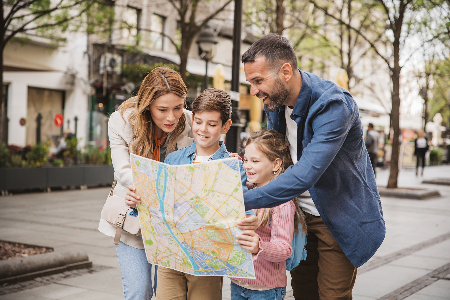 A family on vacation reads a map together.